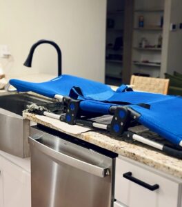 Adaptive hair washing setup for my disabled child’s using a shower chair over a kitchen sink