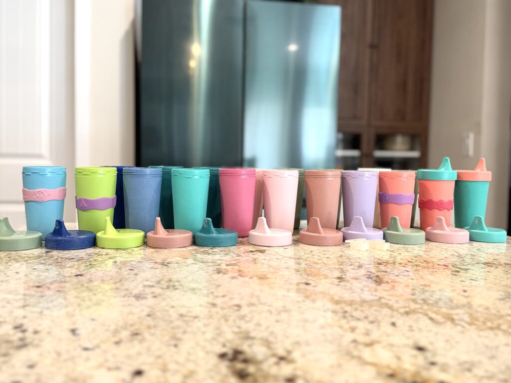Replay no-spill sippy cups for special needs kids in multiple colors on a kitchen counter