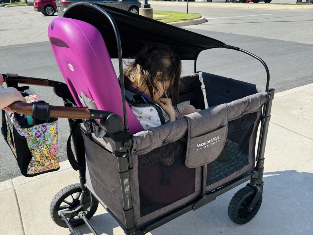 purple Sitter in Wonderfold wagon, outdoor parking lot
Alt text: "Special Tomato Sitter in Wonderfold wagon — adaptive seating insert used in stroller wagon for special needs child