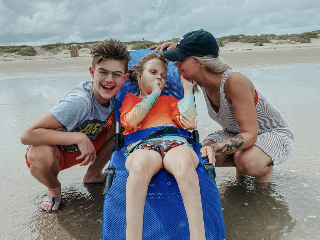 medically complex child in R82 Manatee bath chair at the beach Mustang Island