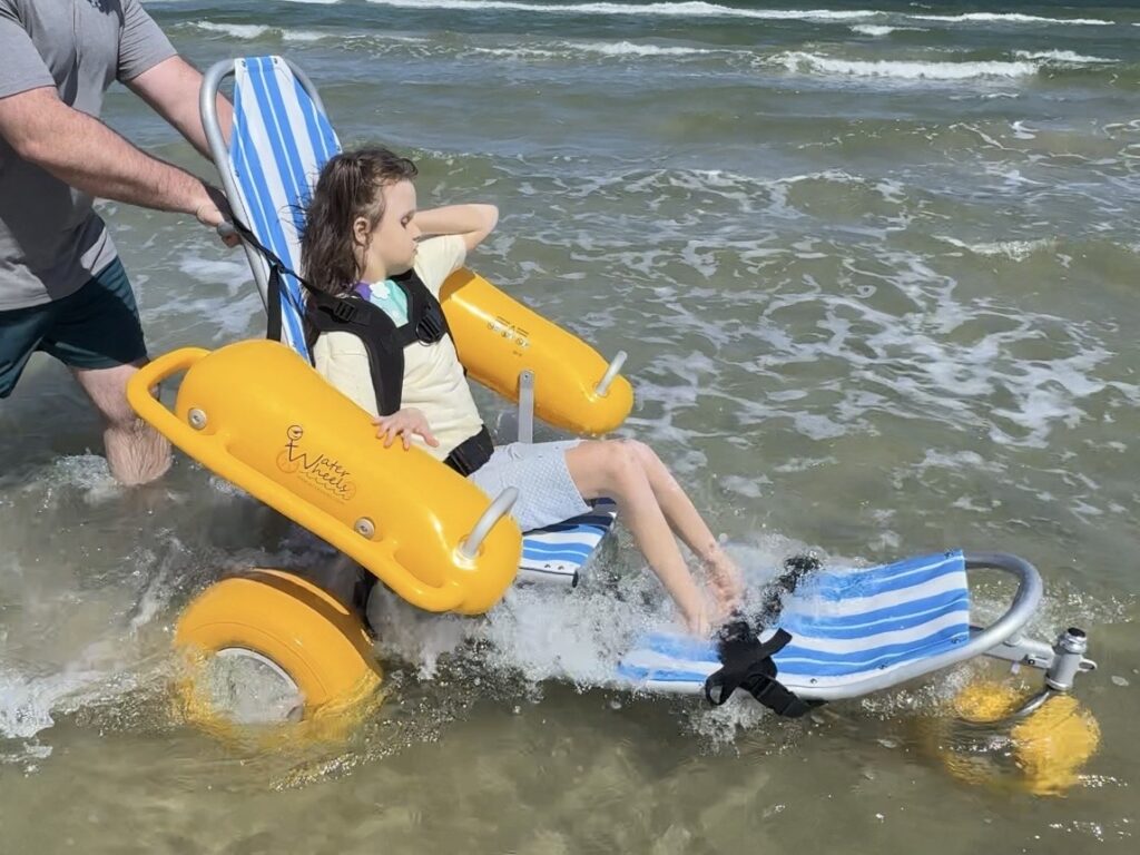 Child in Water Wheels adaptive beach wheelchair in the surf at Mustang Island State Park Texas